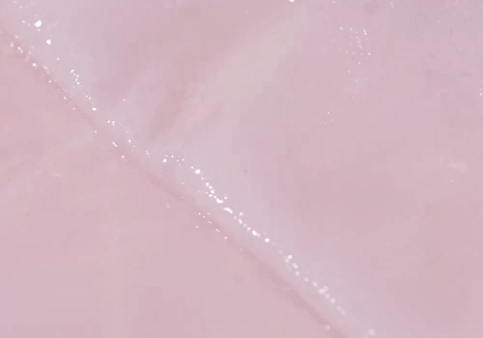Close-up van een vochtig, roze velmasker met glinsterende deeltjes.