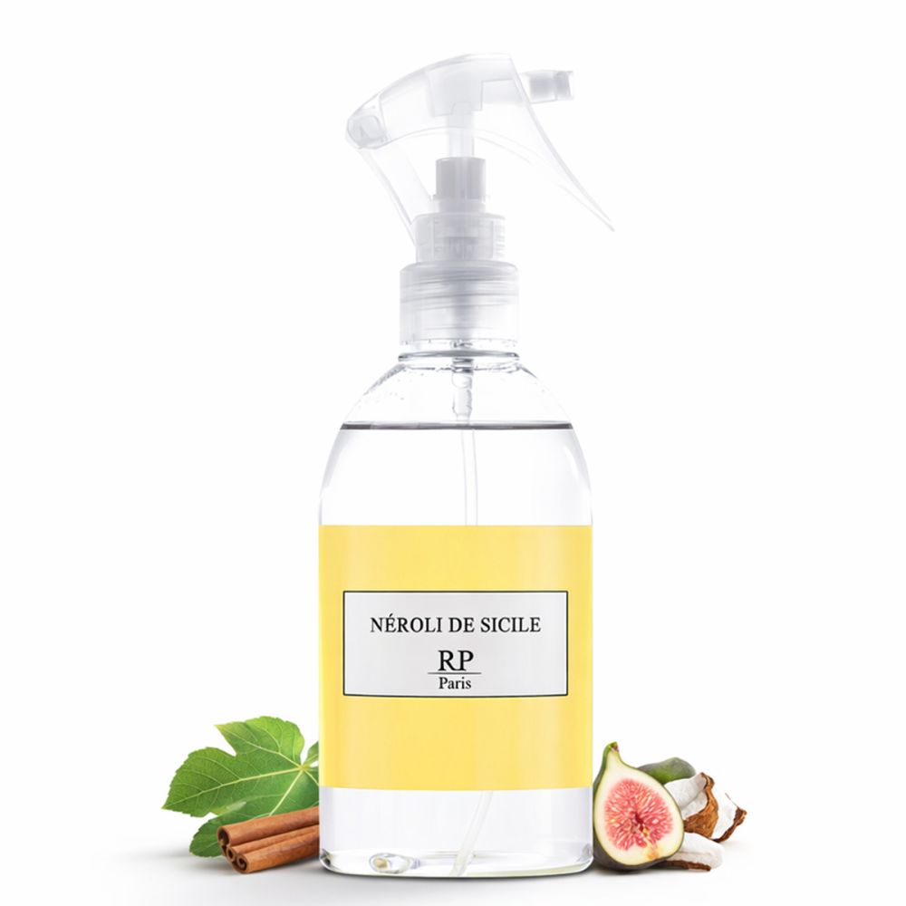 Flacon vaporisateur transparent avec étiquette jaune. Inscription: Néroli de Sicile, RP Paris. Décoration avec figue, bâton de cannelle, feuilles et noix de coco.