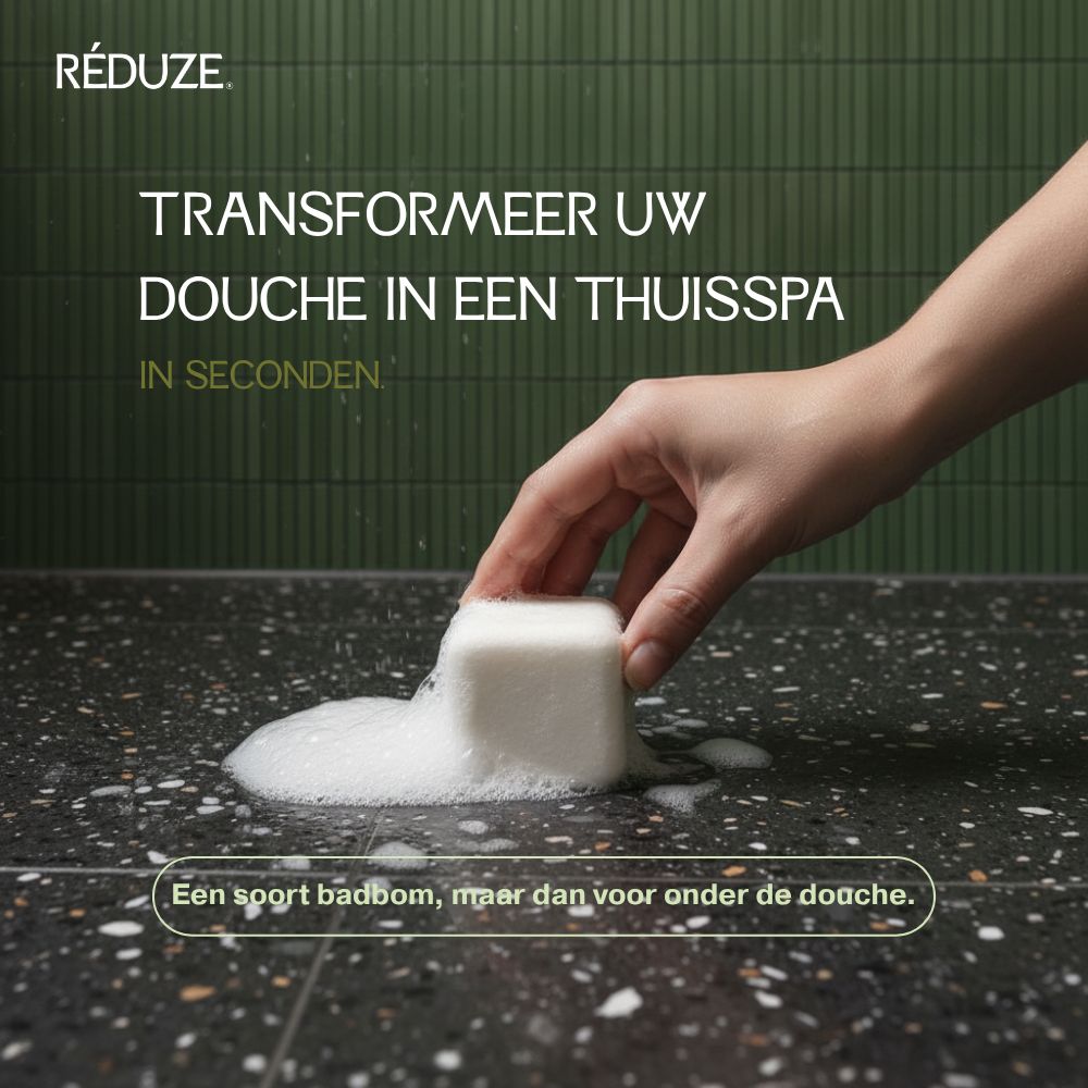 Hand legt wit doucheblokje op een oppervlak met schuim. Tekst: RÉDUZE.