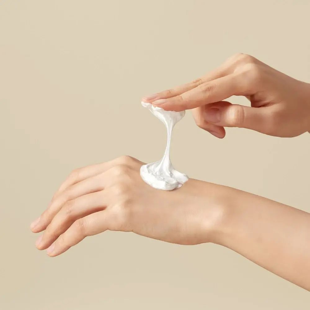 Handen met witte reinigingsschuim op de handpalm.