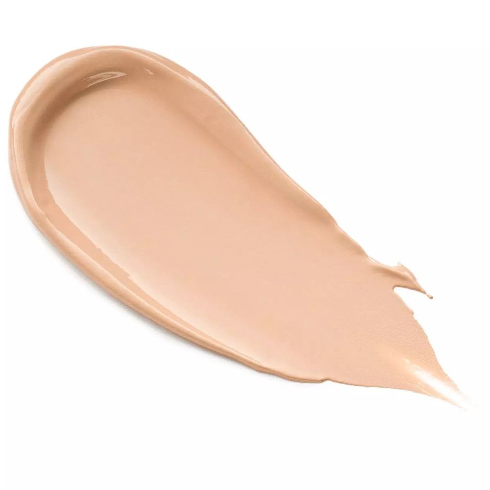 Trace de crème camouflage beige sur fond blanc. La texture est lisse et crémeuse.