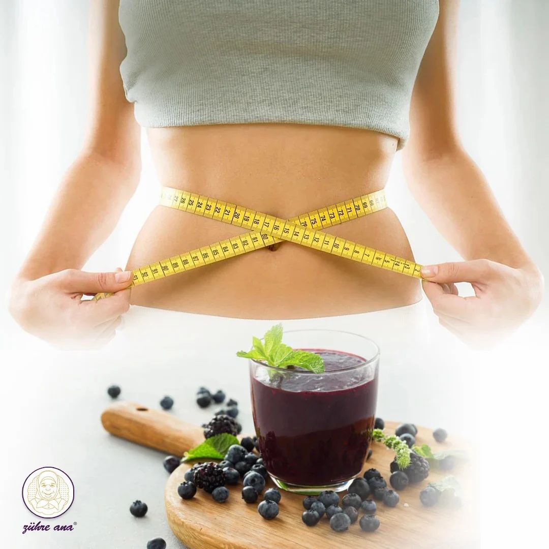 Vrouw met meetlint om taille. Glas smoothie en bessen op houten plank.