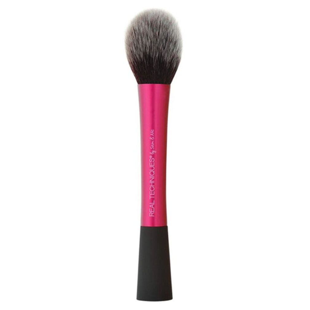 Pinceau à poudre avec manche rose et poils gris-noirs. "REAL TECHNIQUES" est écrit sur le manche.