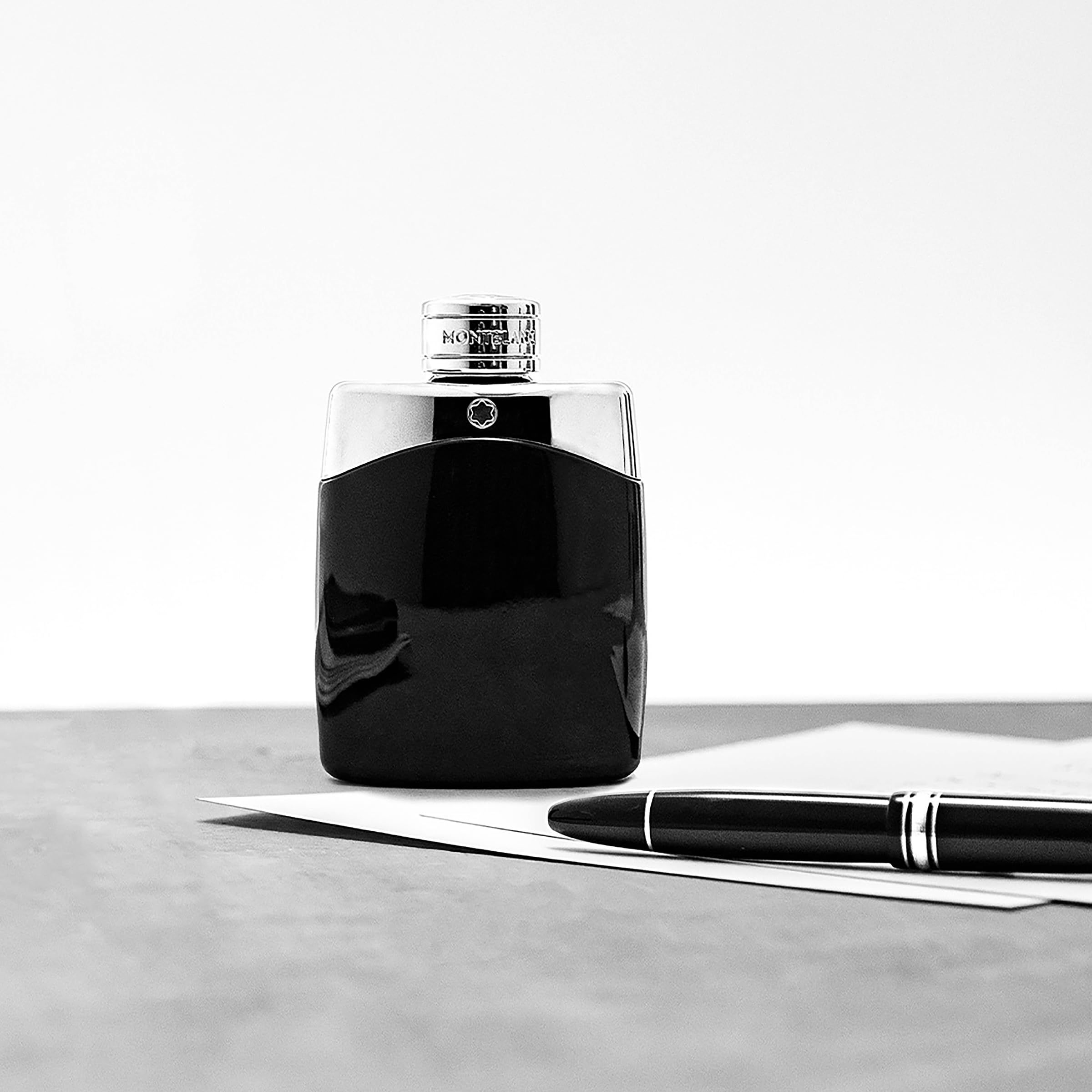 Zwarte flacon met zilveren dop. MONTBLANC-opschrift op de dop. Montblanc-logo op de flacon. Pen ernaast.