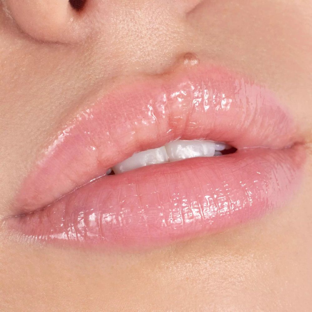 Close-up van lippen bedekt met glanzende lipgloss. Huidskleur.