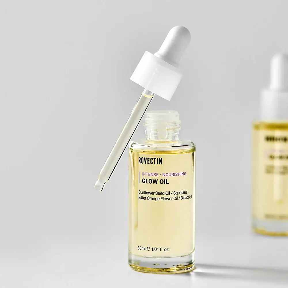 Gezichtsolie fles met open dop en pipet. Transparant, witte dop. Tekst: ROVECTIN, INTENSE / NOURISHING GLOW OIL. 30ml.