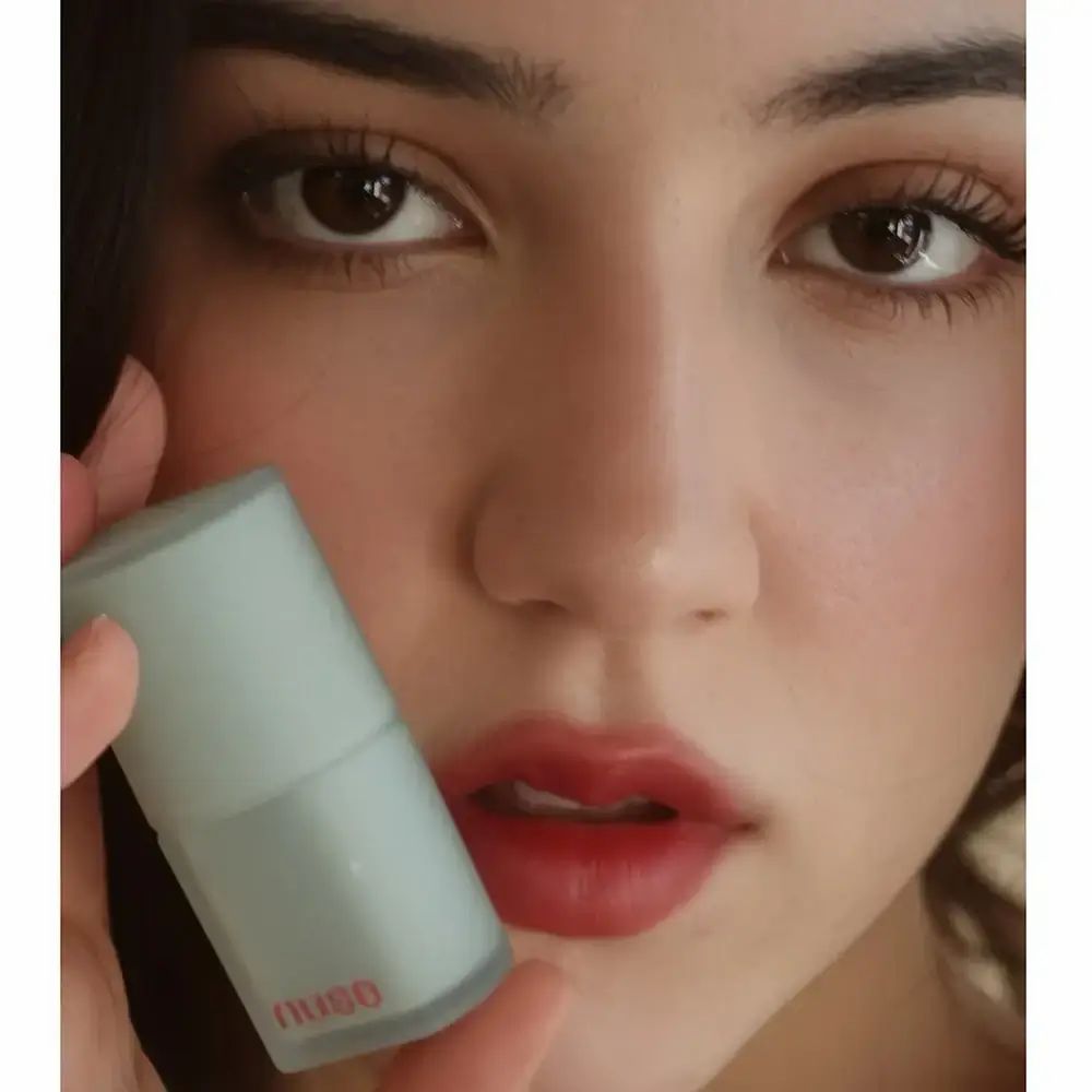 Vrouw met lipstick aangebracht. De lipstickcontainer is lichtblauw en het logo "nuse" is zichtbaar.