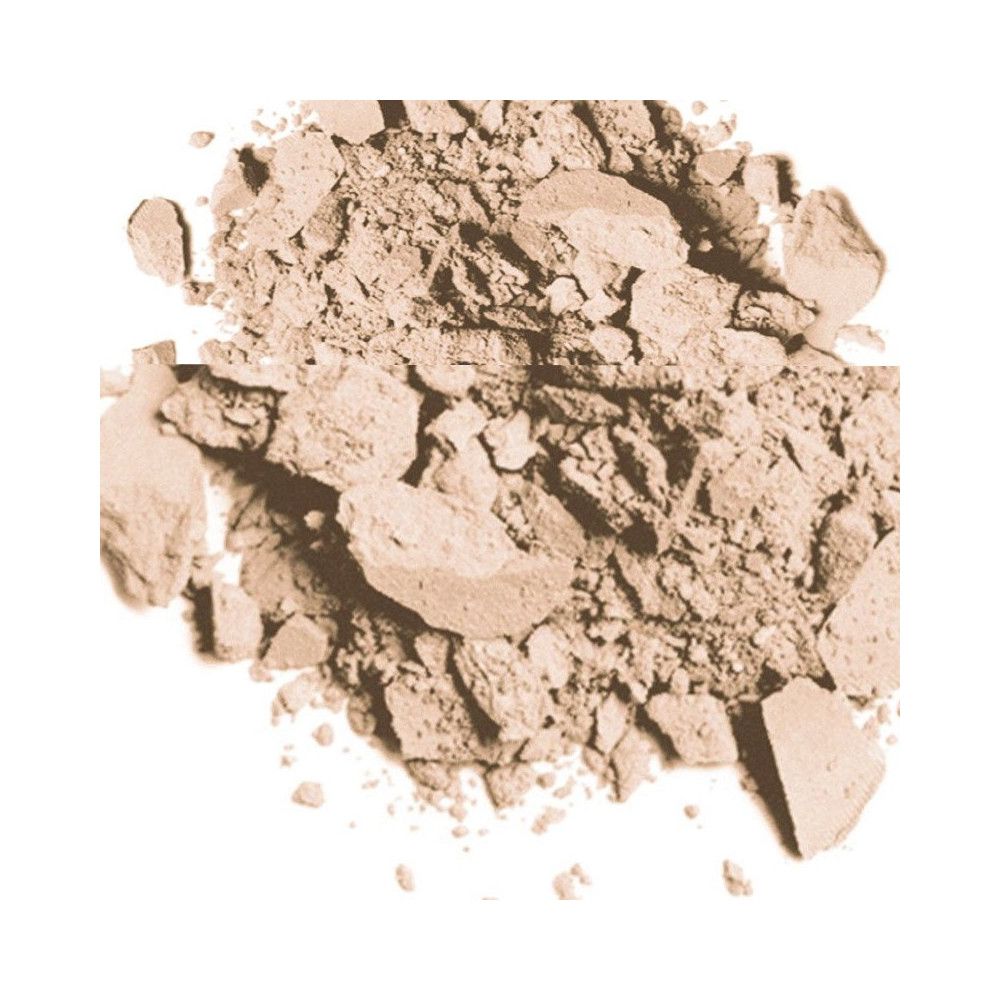 Poudre compacte brun clair broyée sur fond blanc. La texture est friable.