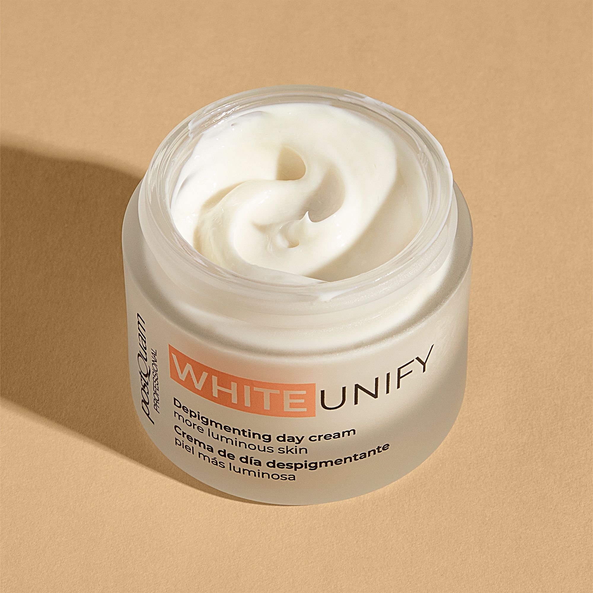 Open crèmepot. Witte crème zichtbaar. Opschrift WHITE UNIFY, Depigmenting day cream, meer stralende huid. Merk Postquam.