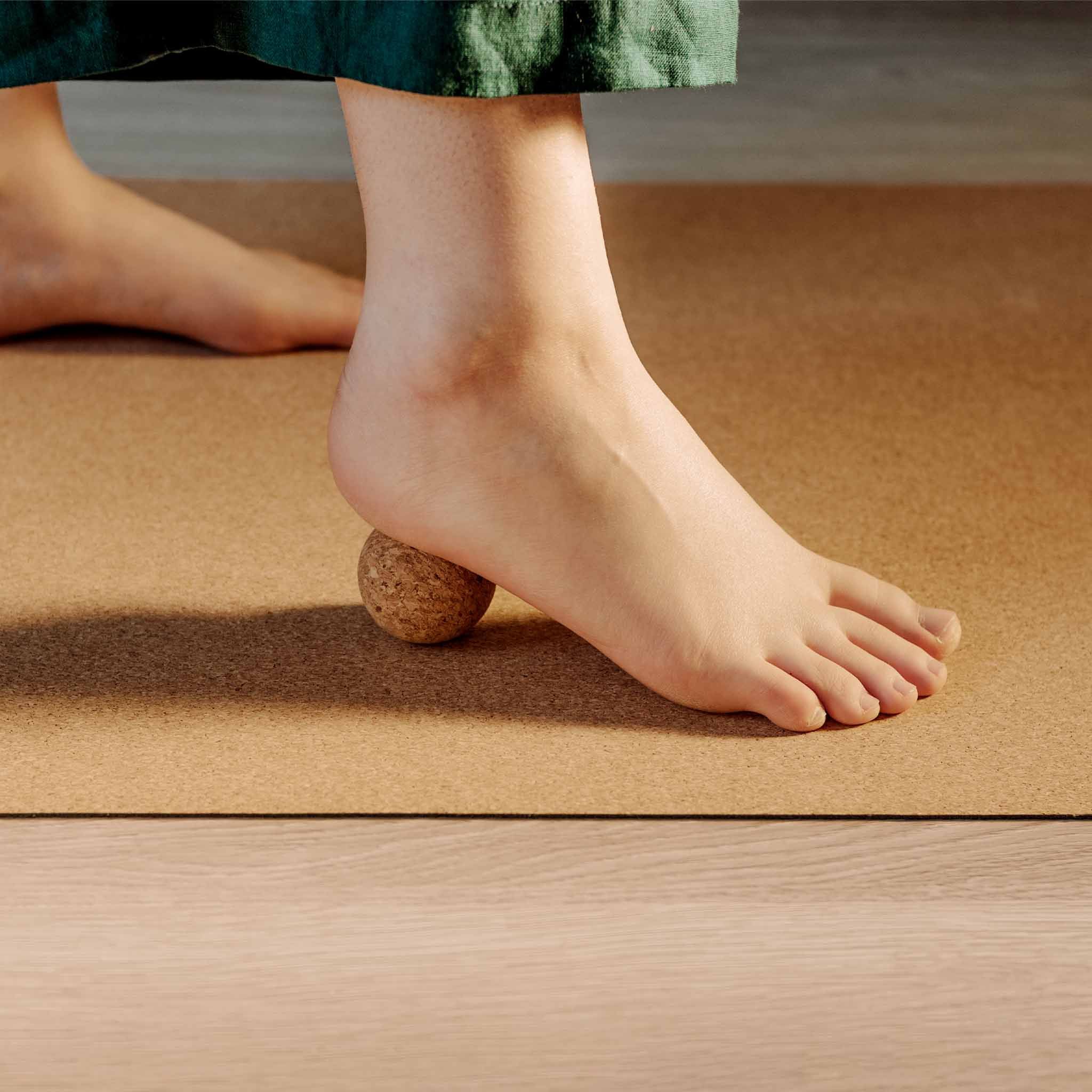 Personne utilisant une balle en liège sous le pied. Sur un tapis. Liège naturel.
