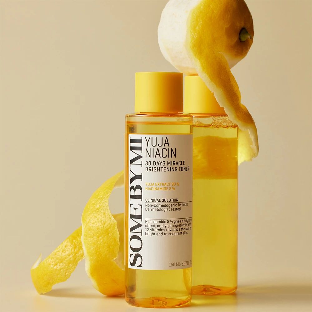 Deux flacons jaunes avec étiquette blanche. Texte : Yuja Niacin, 30 Days Miracle Brightening Toner. Zeste de citron à côté.