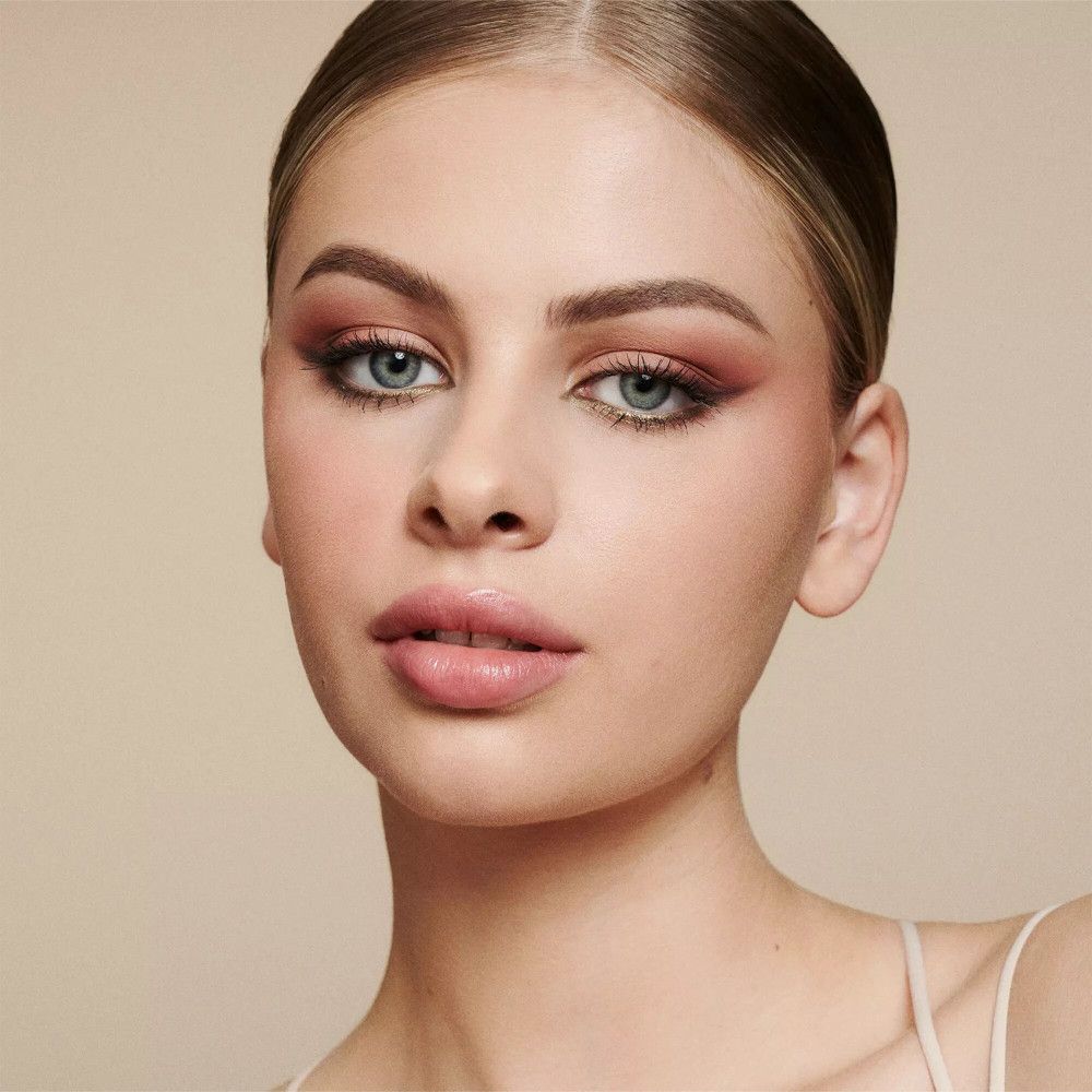 Portret van een vrouw met make-up. Roze lippen, oogschaduw, lichte teint.