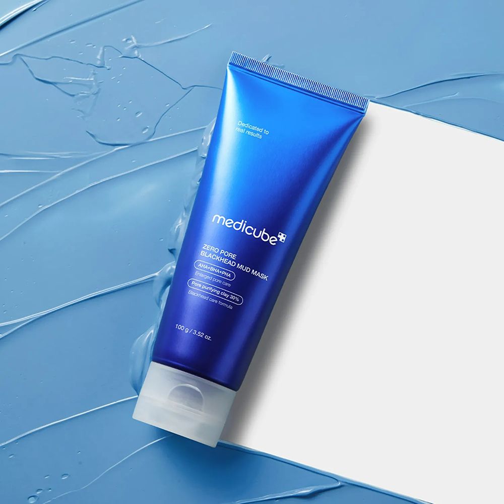Blauwe tube op blauwe achtergrond en wit papier. Opschrift: medicube, Zero Pore Blackhead Mud Mask. Tekst: AHA+BHA+PHA, Pore purifying clay 30%.