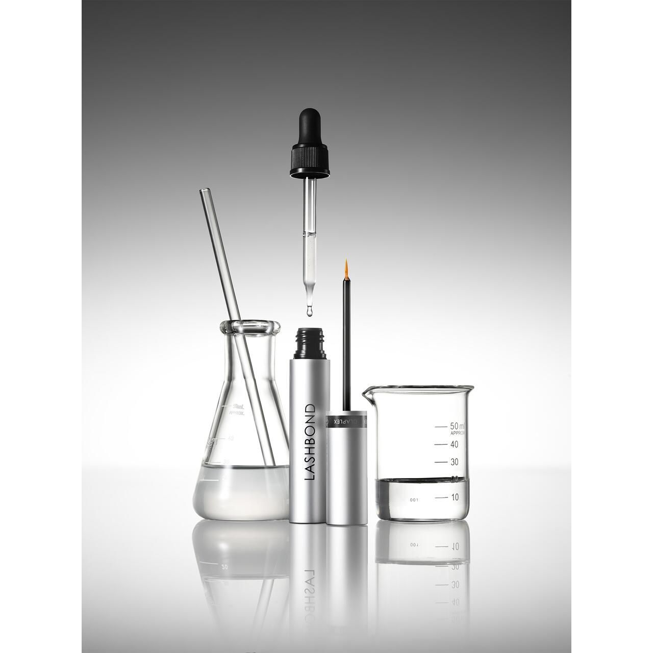Scène de laboratoire avec produit et équipements. Le produit est dans un tube argenté avec applicateur.