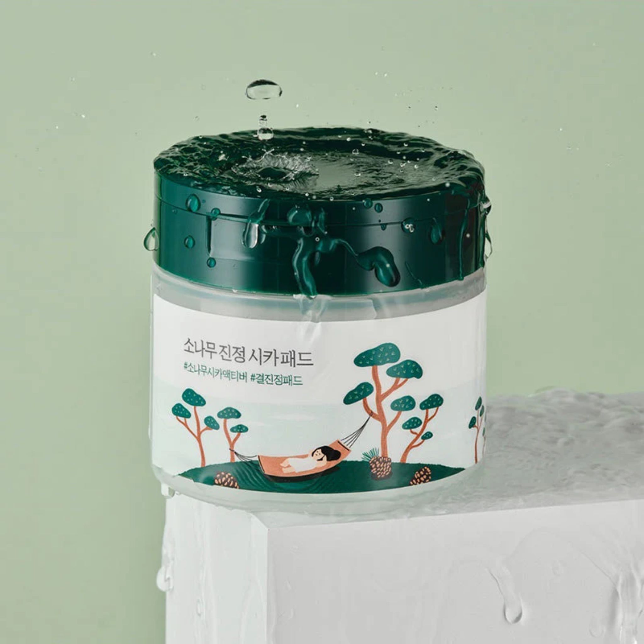 Round Lab Lab Pine Calming Cica Pad: pot met waterdruppels en dennen-cica-motief.