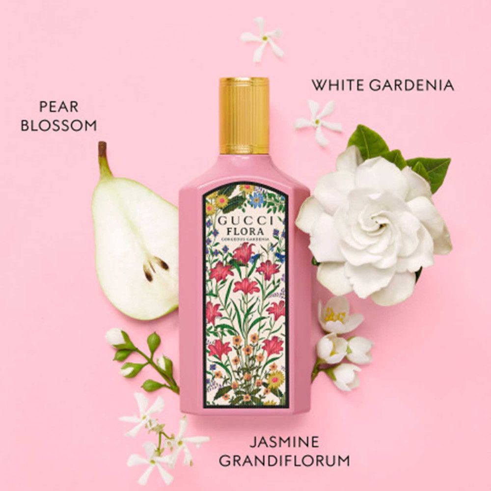 Flacon rose Gucci Flora avec bouchon doré. Fleurs de gardénia blanc, poire et jasmin. Texte: Pear Blossom, White Gardenia, Jasmine Grandiflorum.