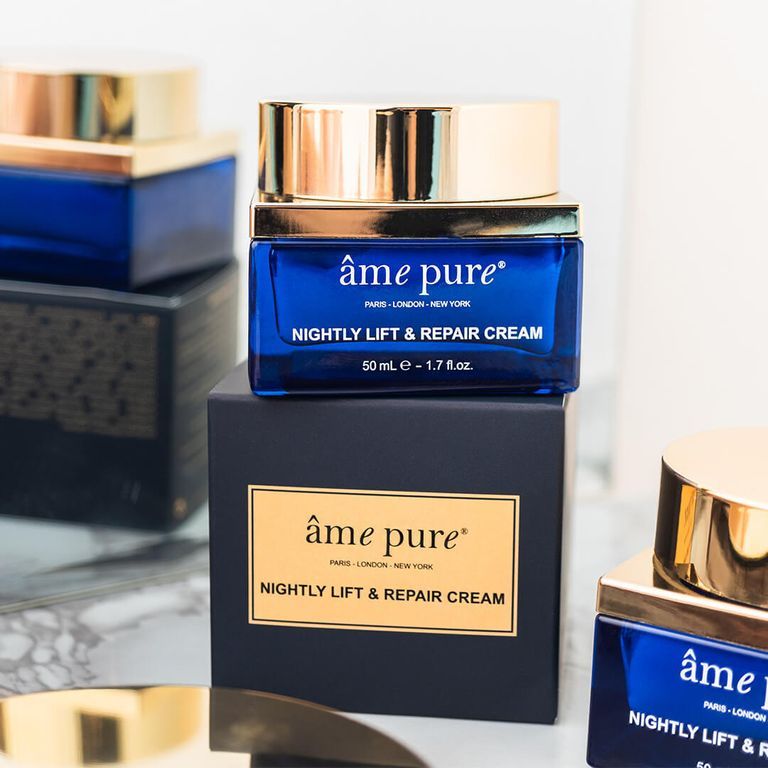 Een potje âme pure Nightly Lift & Repair crème op een donkere doos. Blauw glazen potje met gouden deksel.
