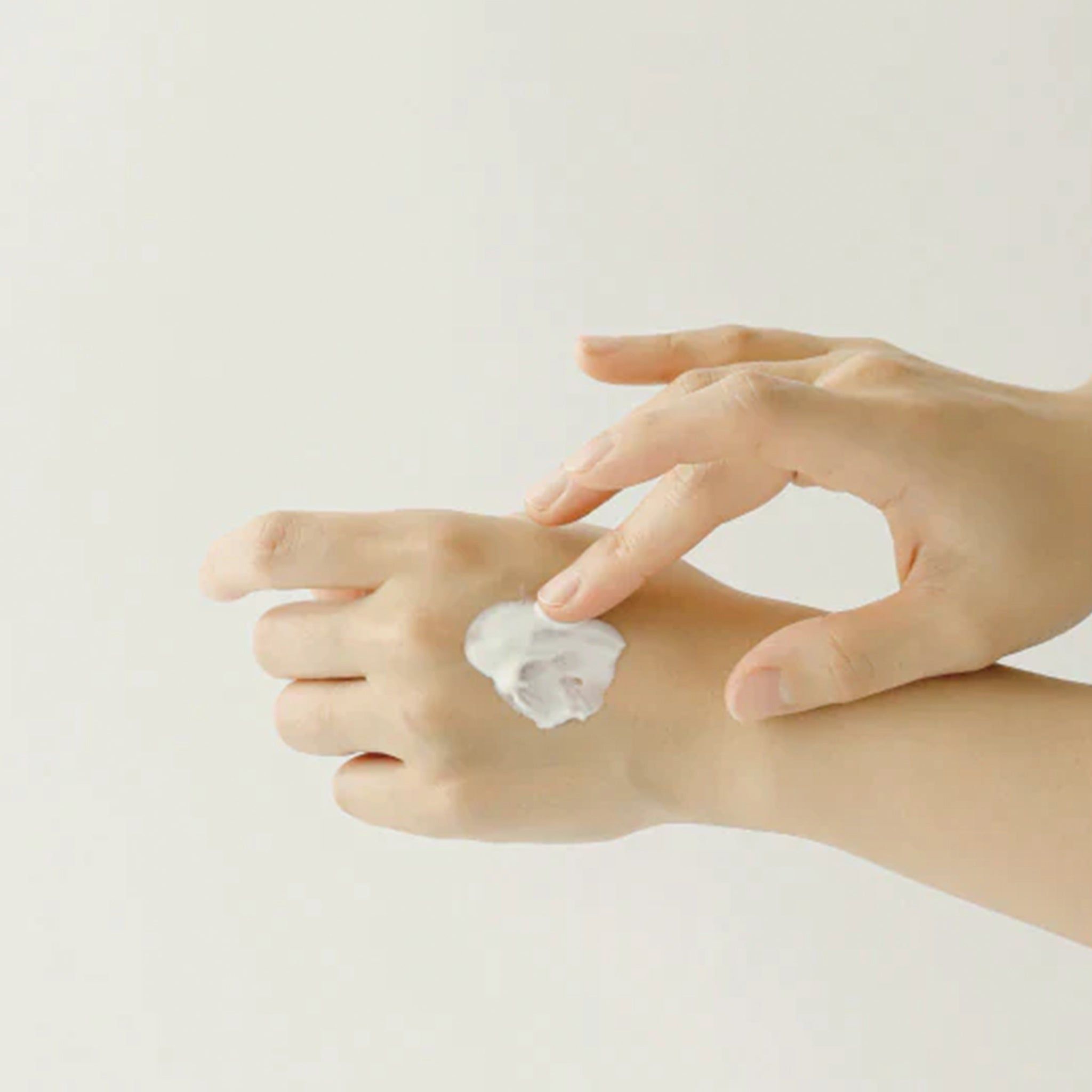 Mains appliquant de la crème sur la peau. Crème sur la paume.