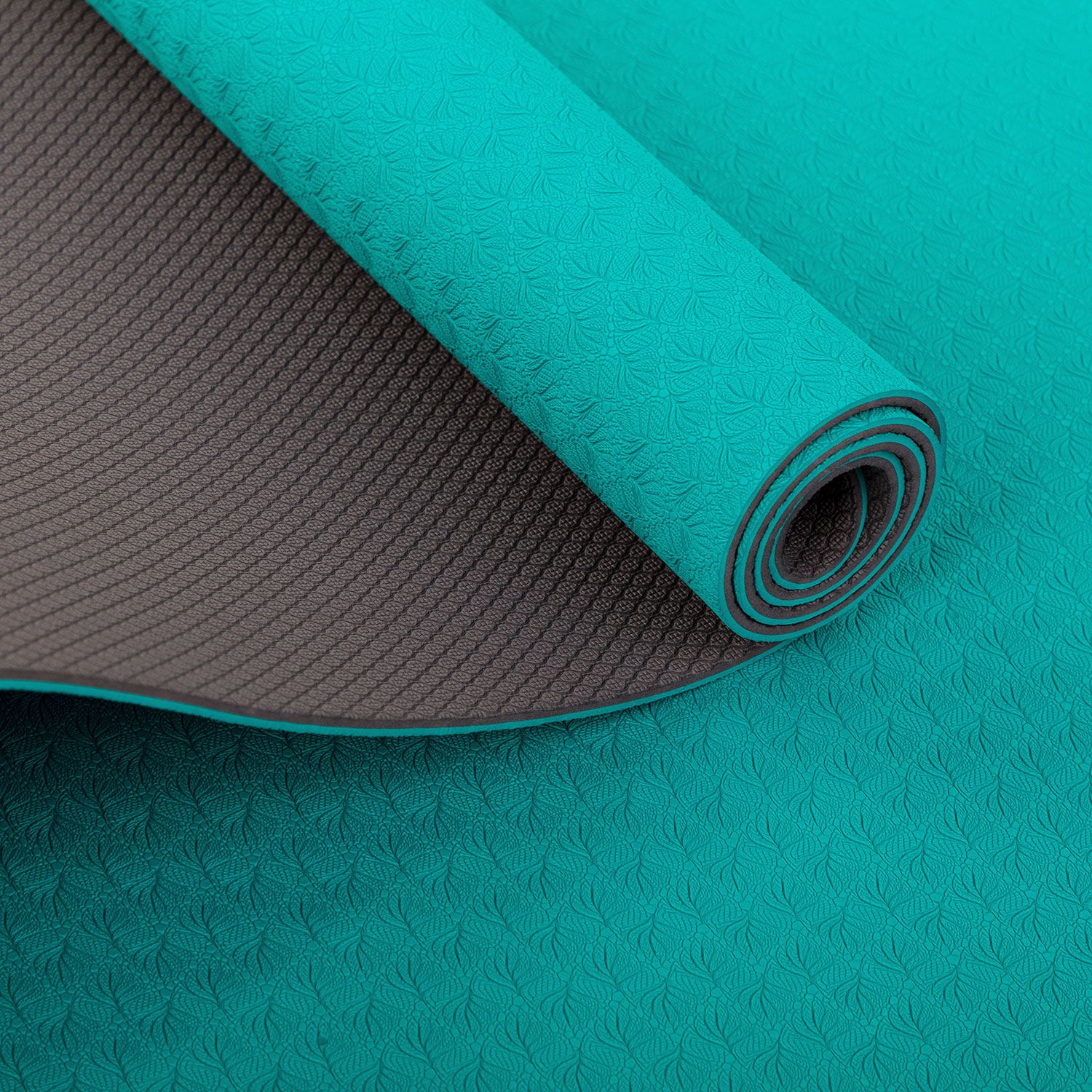 Opgerolde yogamat, turquoise en grijs. Detail van de opgerolde uiteinden. Gestructureerde oppervlakken.