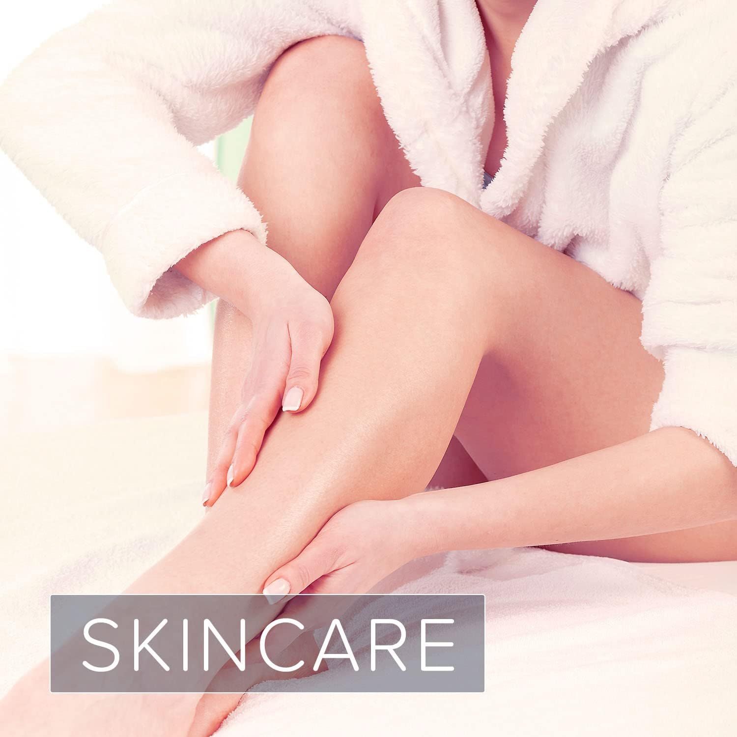 Persoon die haar benen insmeert. Ze draagt een witte badjas. Tekst: SKINCARE.