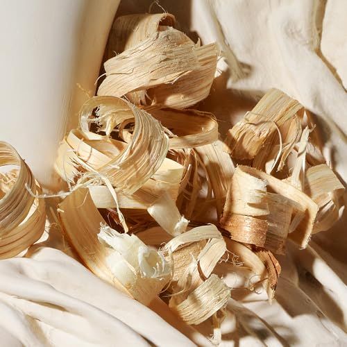 Close-up van houtsnippers op lichte stof. Krullen in verschillende maten en vormen, bruin en beige.