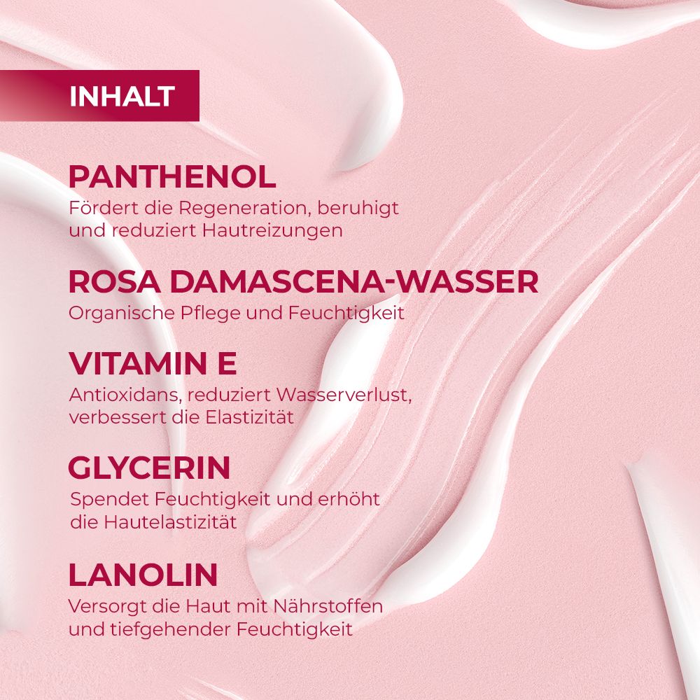 Close-up van crème streken. Tekst: Panthenol, Rozenwater, Vitamine E, Glycerine, Lanolin. Roze achtergrond.