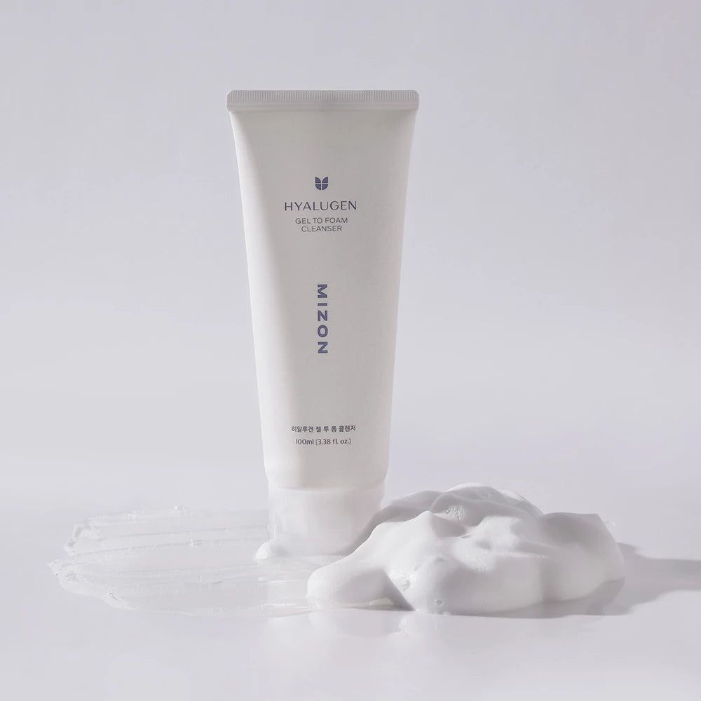 Tube blanc avec produit et mousse. Inscription HYALUGEN, GEL TO FOAM CLEANSER, MIZON. Mousse à côté.