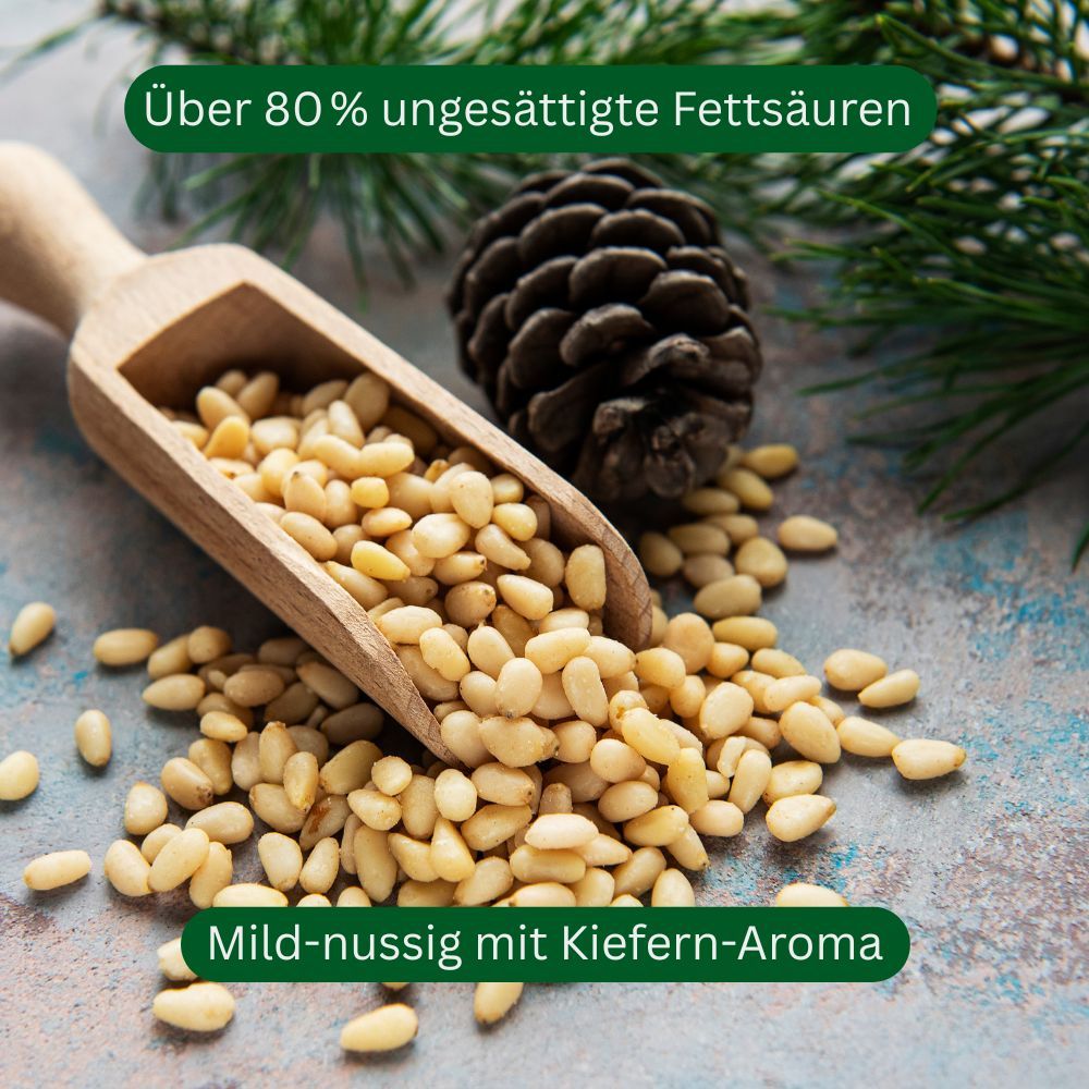 Houten schep met pijnboompitten. Naast dennenappel en takken. Tekst: Meer dan 80% onverzadigde vetzuren, Mild-nootachtig met dennenaroma.