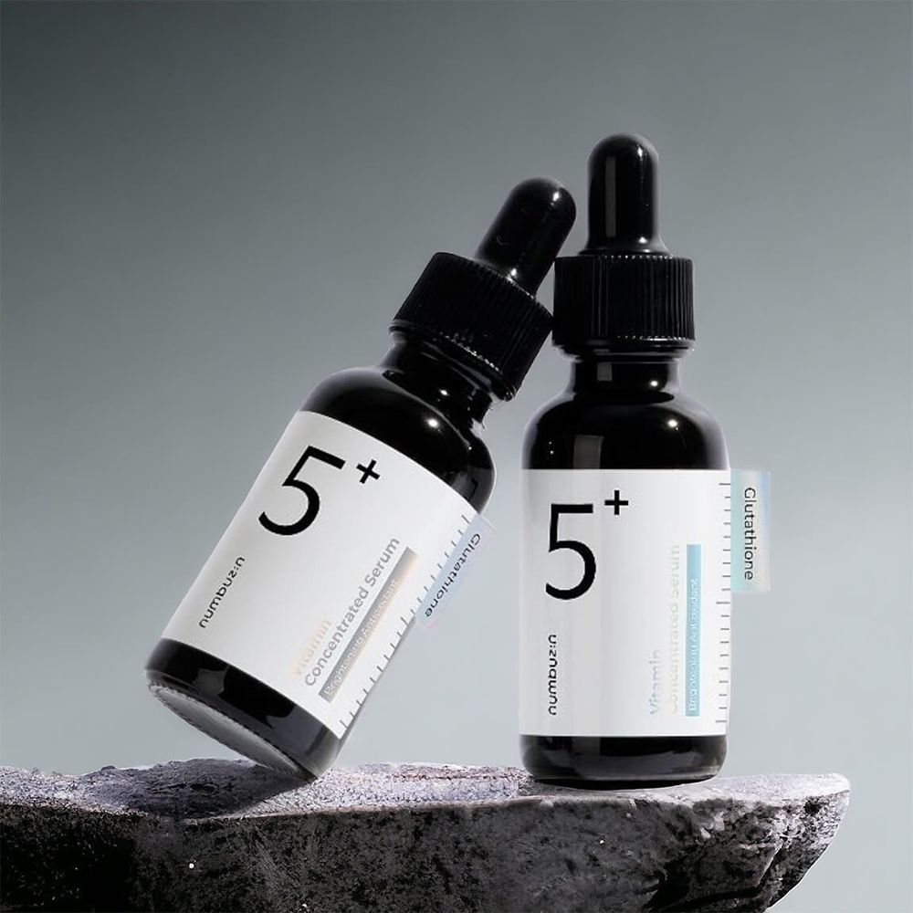Deux flacons noirs avec pipettes. Étiquette avec texte: Vitamin Concentrated Serum, Glutathione. Inscription: 5+.