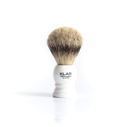 Witte scheerkwast met lichte haren en witte handgreep. De handgreep draagt de tekst "KLAR". 