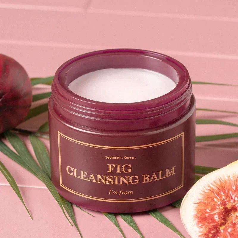 Open donkerrode pot met witte balsem. Opschrift: FIG CLEANSING BALM, I'M FROM. Vijg en blad.