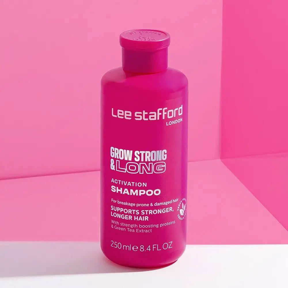 Bouteille de shampooing activateur LEE STAFFORD Grow Strong & Long sur fond rose.