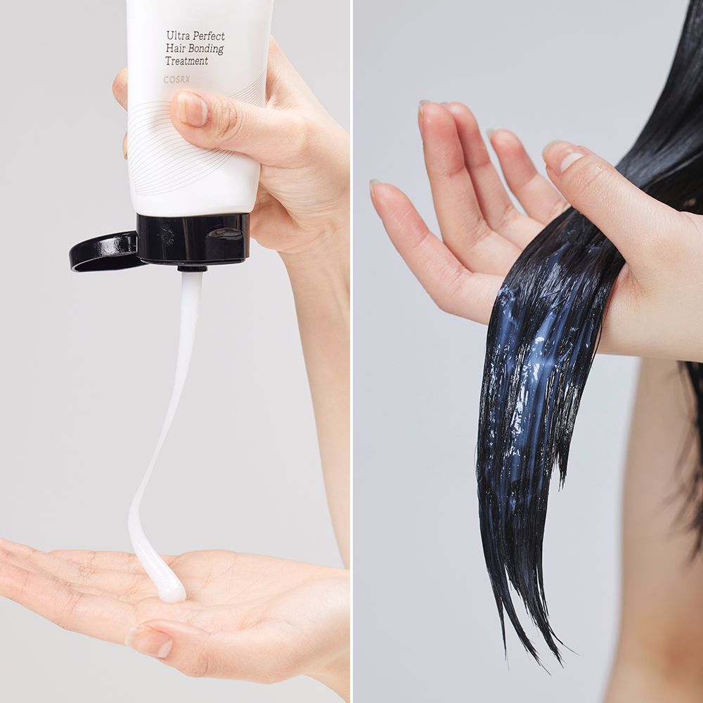 Twee handen: één knijpt witte crème uit een tube, de ander houdt nat, donker haar vast.