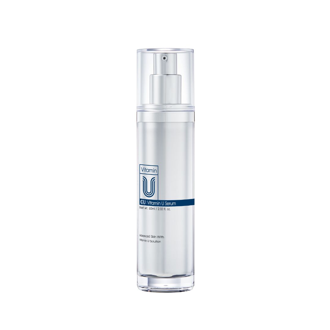 Cilindrische fles met sproeikop. Opschrift: Vitamin U Serum. Blauwe horizontale lijn met tekst.