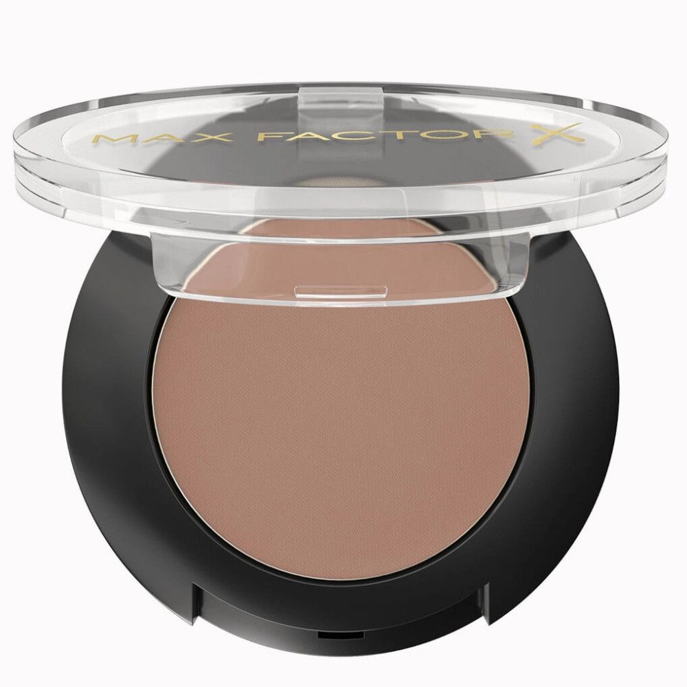 Ronde, bruine oogschaduw in een zwarte houder met transparante deksel. Gouden tekst op de deksel.