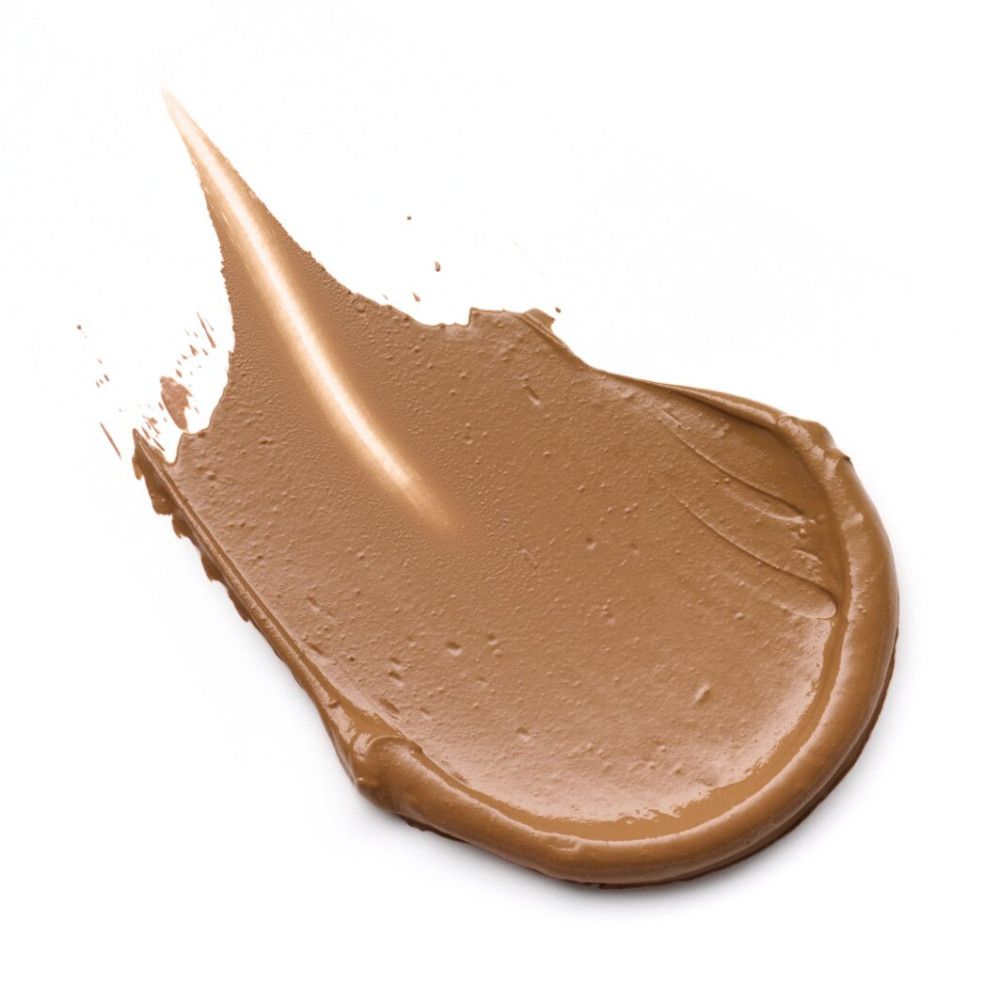 Fond de teint étalé. Teinte marron. Sur fond blanc.