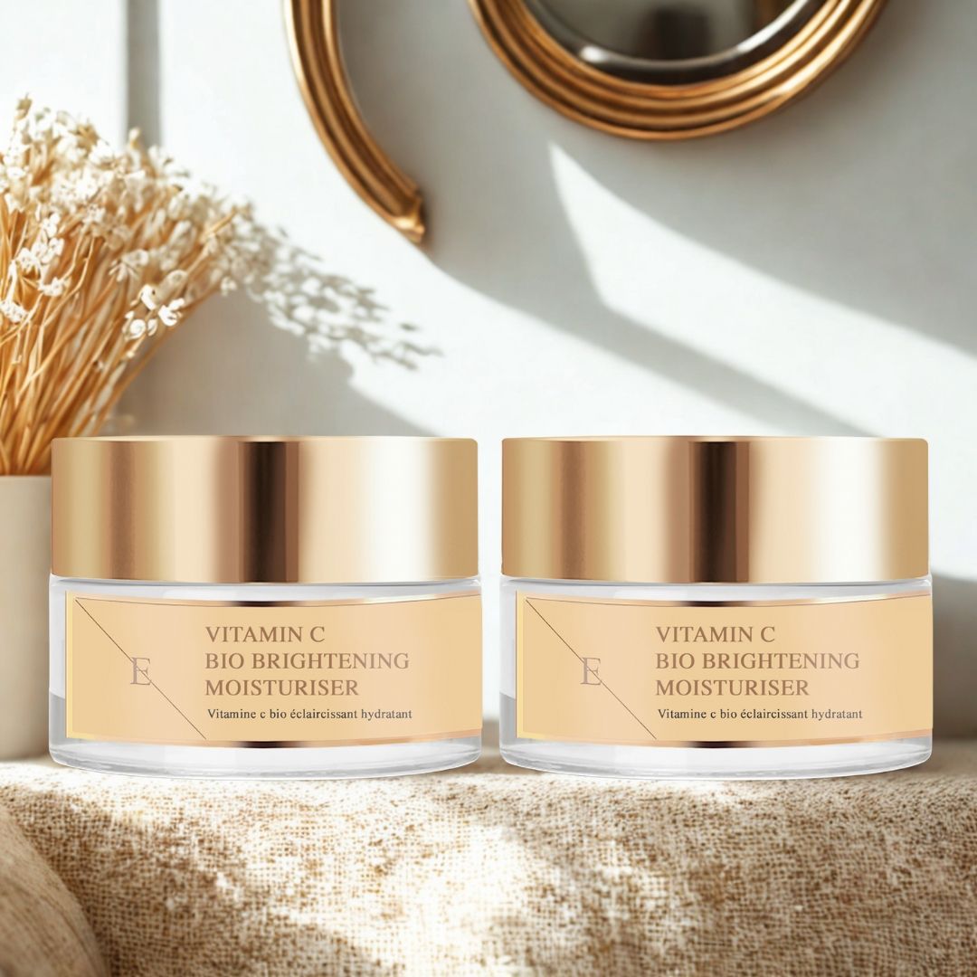 Twee potten ErthSkin London Vitamin C Bio Brightening Moisturizer. Glazen potten met gouden deksels. Geplaatst op een plank.