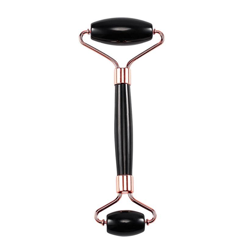 Zwarte jade roller met koperkleurig metalen frame op witte achtergrond.