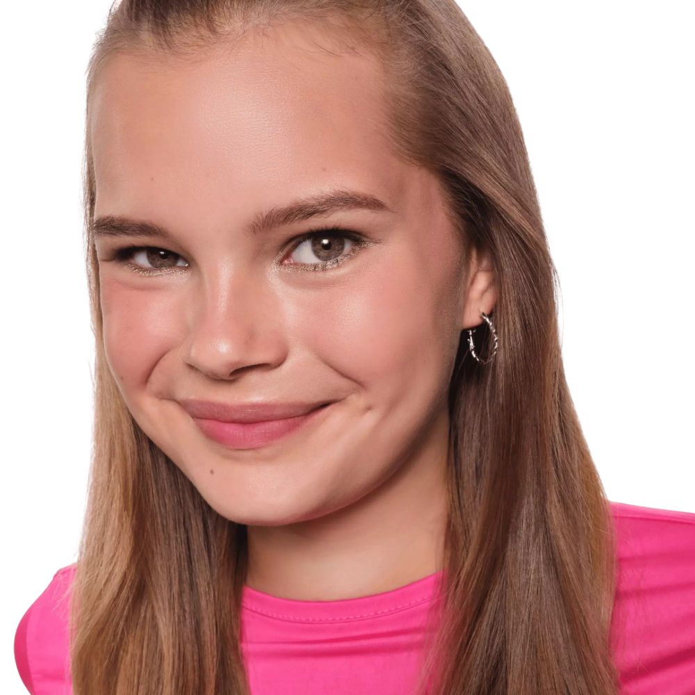 Portrait d'une jeune fille en haut rose. Elle a de longs cheveux bruns et porte des boucles d'oreilles.