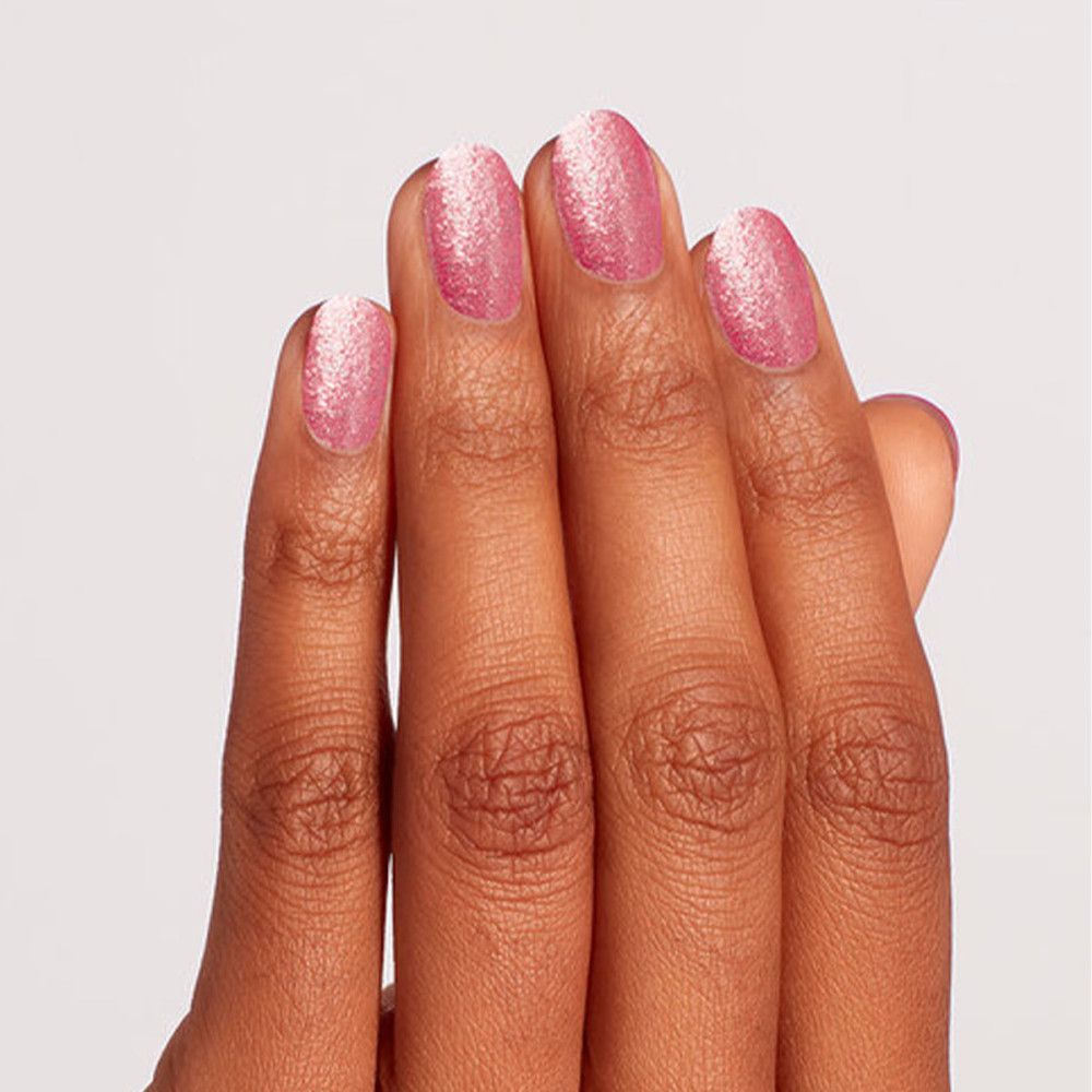 Hand met vier vingers gelakt met roze glitter nagellak.