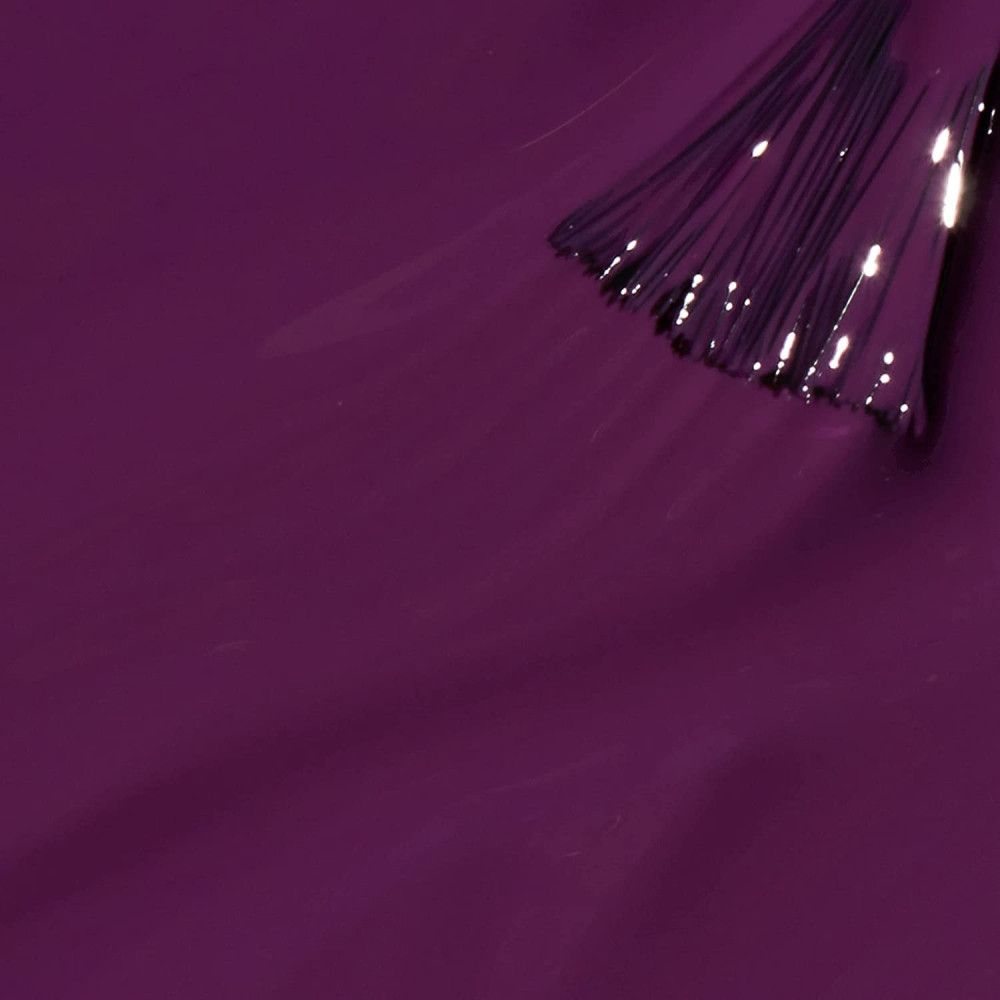 Donkerviolette nagellak met penseel. Close-up. Penseelharen in lak gedoopt. Glanzend oppervlak.