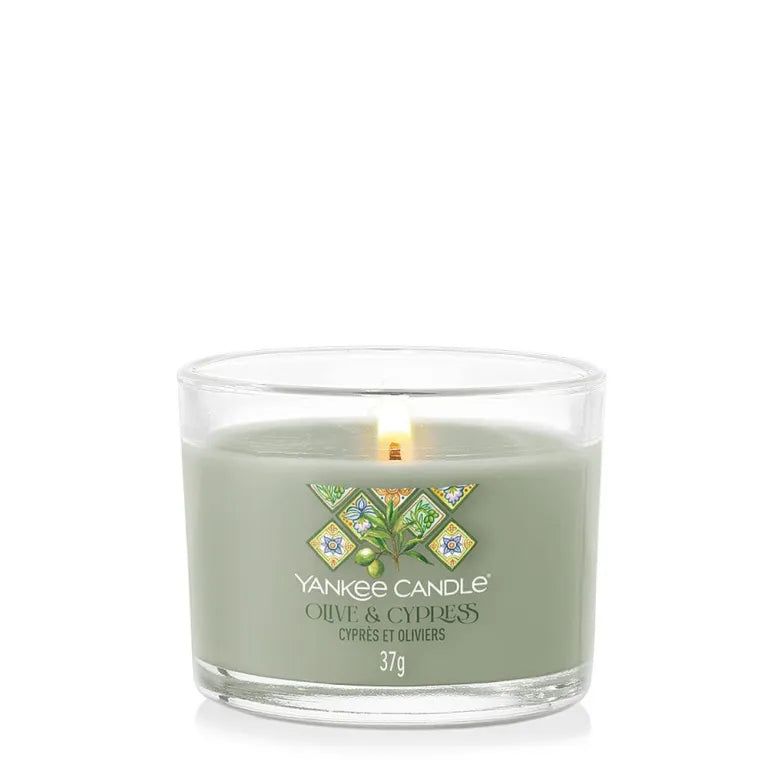 Bougie verte en verre. Étiquette Olive & Cyprès. Inscription: Yankee Candle, Olive & Cypress, 37g. Mèche allumée.