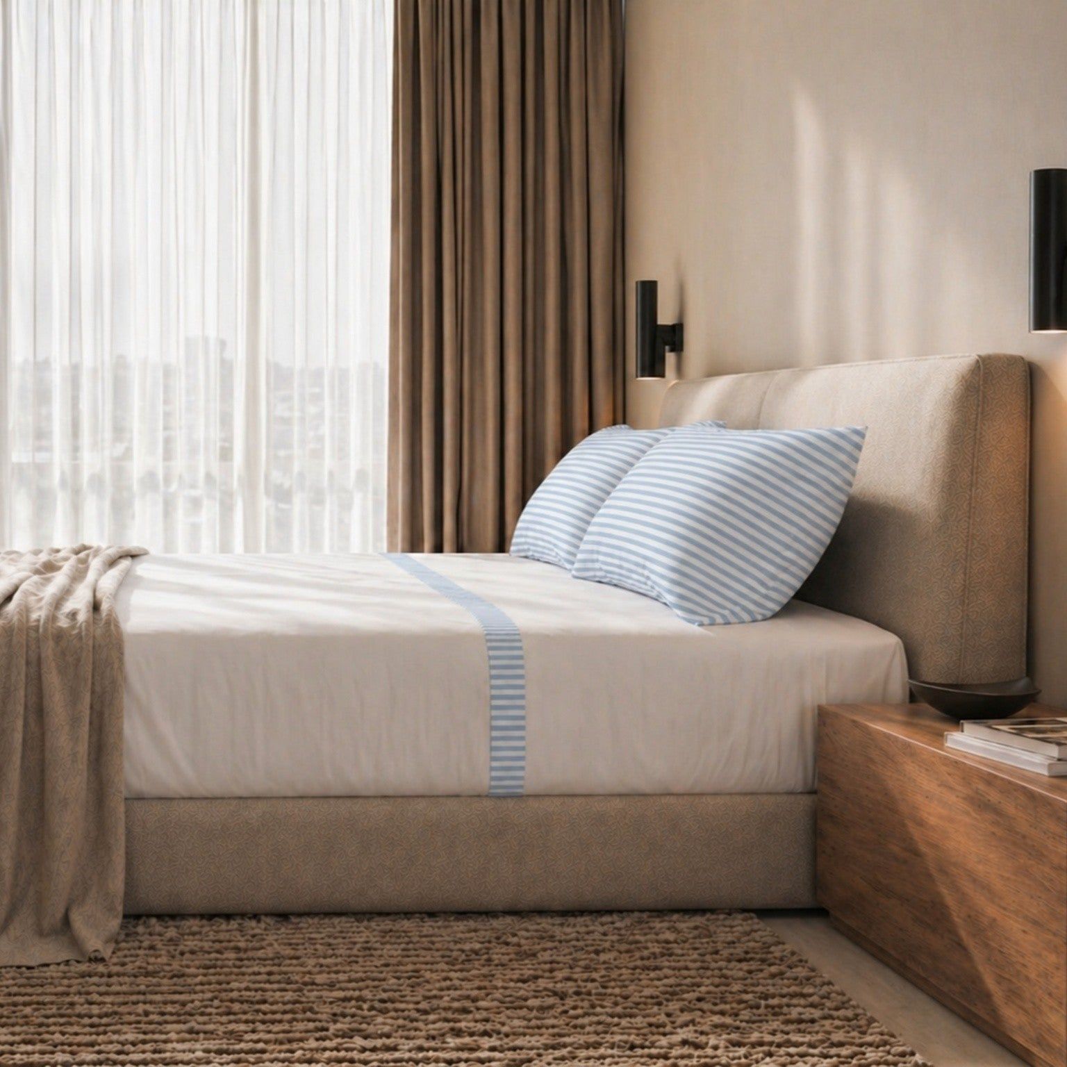 Een opgemaakt bed met gestreept dekbedovertrek en een wit gestreept laken.