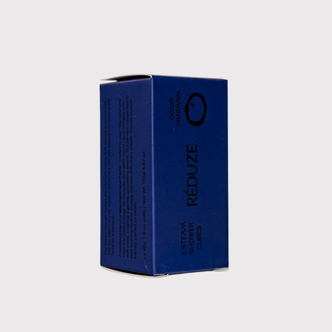 Blauwe doos met productinfo. RÉDUZE. Zedernholz & Mandarine. 3 Steam Shower Cubes. Zijaanzicht.