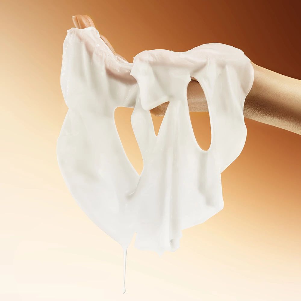 Un masque facial blanc est tenu par une main. Le masque a des ouvertures pour les yeux et la bouche.