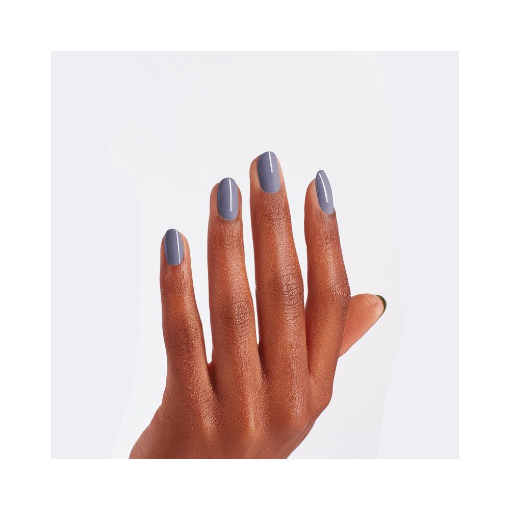 Main avec ongles vernis en violet. Finition brillante.