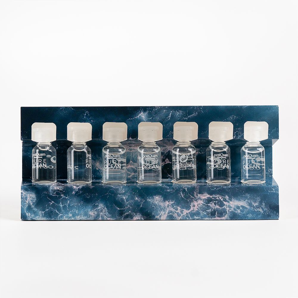 Sept petites ampoules en verre avec bouchons blancs. Inscription "PURE OCEAN". Sur un support à motif marin.