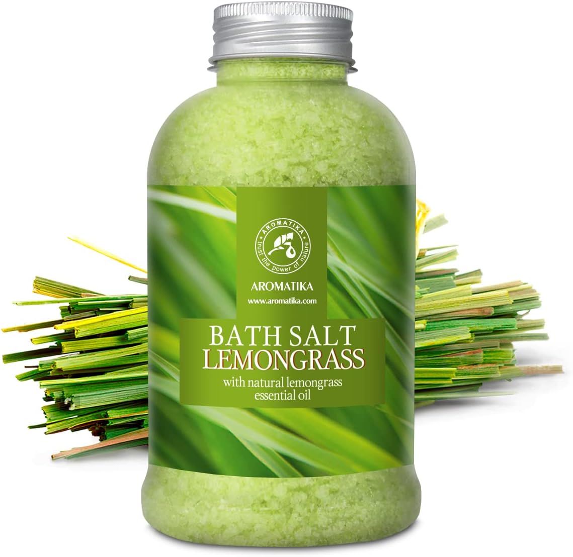 AROMATIKA Sel de bain Lemongrass en bouteille, à côté d'une botte de citronnelle fraîche. Sel vert et étiquette avec des herbes.