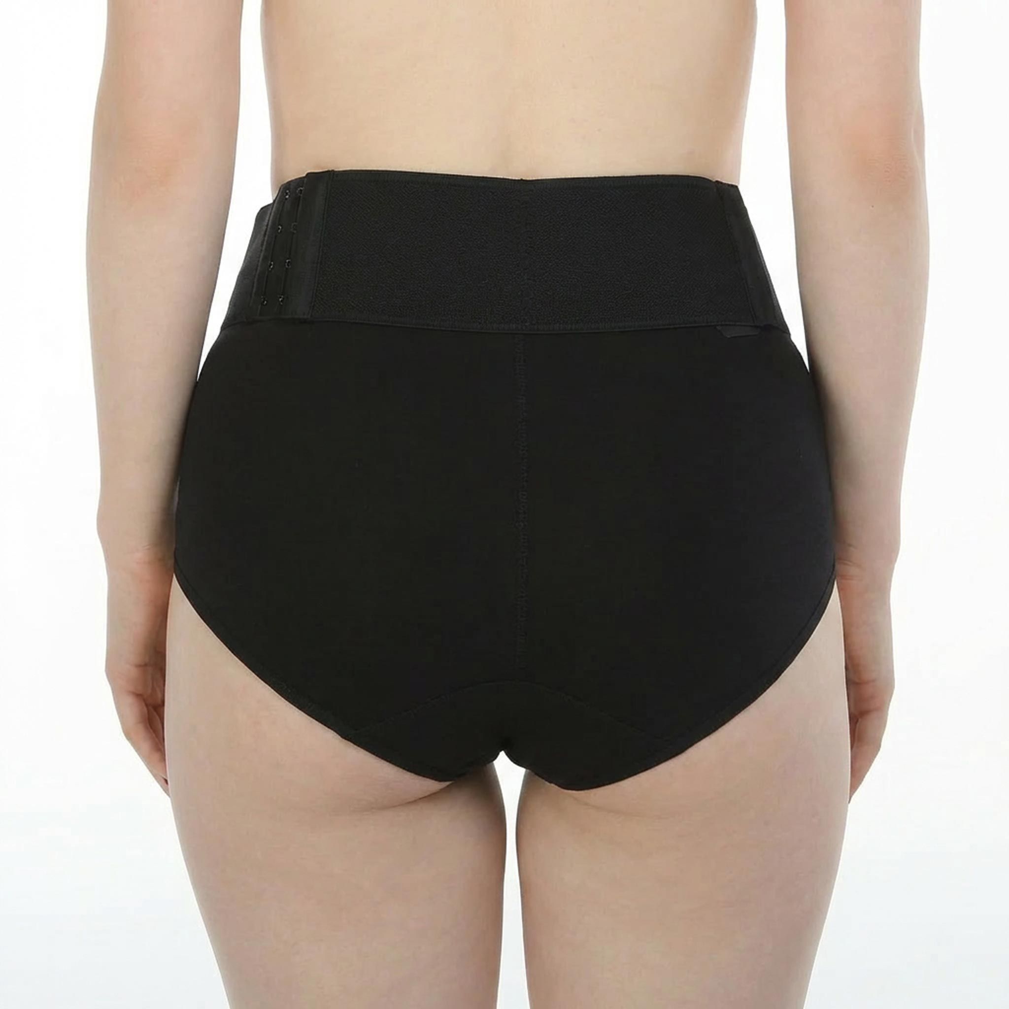 Gaine noire, vue arrière. Femme, de dos, hanches et fessiers visibles.