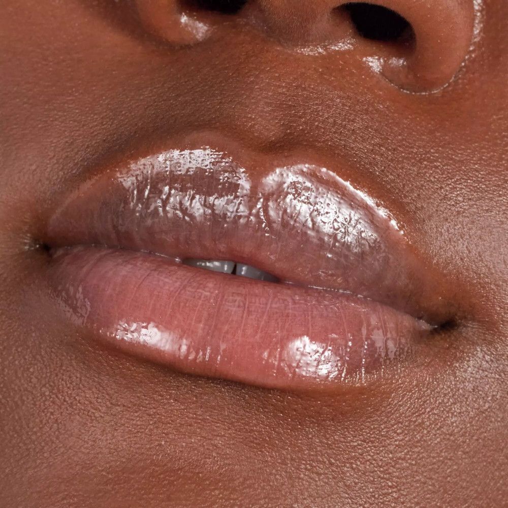 Close-up van lippen met glanzende, roze lipgloss. De lippen zijn licht geopend.